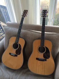 two guitars sitting on top of a couch