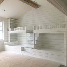 an empty room with white painted walls and wooden flooring on the bottom level is a bunk bed