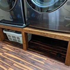 a washer and dryer sitting next to each other in a room with wood floors