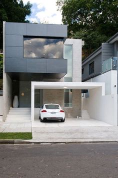 a white car parked in front of a modern house