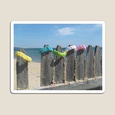 there are many hats on the fence by the beach