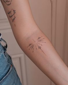 a person with a tattoo on their arm holding something in her hand and looking at the camera