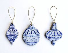 three blue and white ornaments hanging from hooks