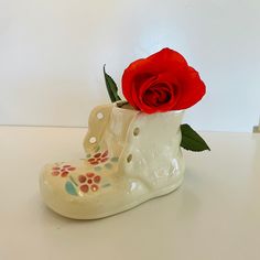 a white boot with a red rose in it