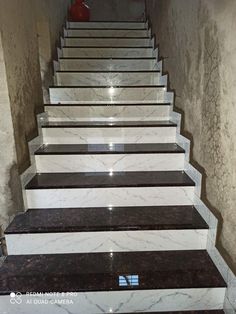 marble steps leading up to the top of a staircase in a building with white and black trim