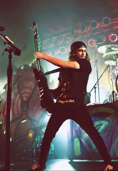 a man holding a guitar on top of a stage