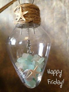 a sea glass ornament with starfish and shells in it hanging from a rope