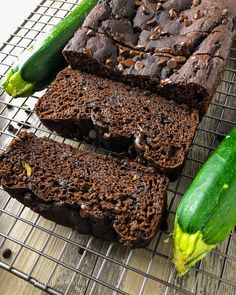 a loaf of chocolate zucchini bread on a cooling rack with cucumbers