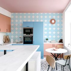 a kitchen with pink, blue and white wallpaper