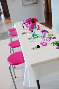 the table is set up with pink and green decorations on it, along with other items