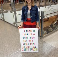 a woman holding a sign that says i tried to think of a cute sign but all i could think of was your cut's face