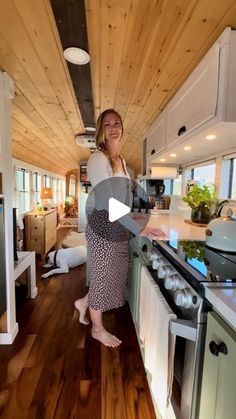 a woman standing in a kitchen next to an oven