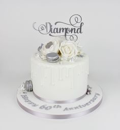 a white wedding cake with flowers on top and the word diamond written in cursive writing