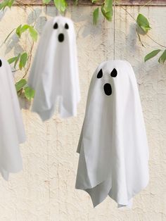 three ghost - like decorations hanging on a wall