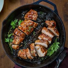 some meat is cooking in a skillet on the table