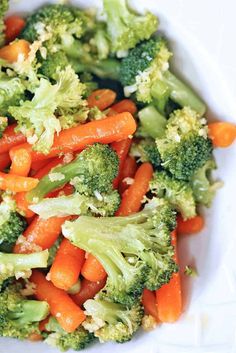 a white bowl filled with carrots and broccoli on top of a table