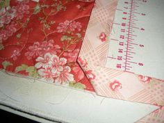 two pieces of fabric sitting on top of a table next to a measuring tape and ruler