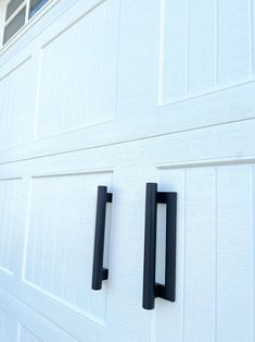 two black handles on the side of a white garage door