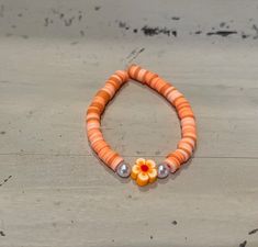 This listing is for one handmade bracelet with various shades of orange and light peach. It also has two small pearl-like beads on either side of an orange flower bead.**SHIPPING INCLUDED** This bracelet is offered in three sizes. Please check the Sizing Guide carefully before ordering. Ages listed are approximate. Please measure before ordering. We do not offer returns, but please email if you are not fully satisfied.  **SIZING GUIDE** Little Kid (Ages 5-7) Bracelet length is 5.75" long. Big Kid (Ages 8-11) Bracelet length is 6.25" long. Standard (Ages 12+) Bracelet length is 6.75" long.  Our bracelets are triple-knotted, but should not be overstretched. CHOKING HAZARD for young children. All of our bracelets arrive nicely packaged. Please let us know if you'd like to include a free, hand Orange Flower Jewelry For Beach, Orange Flower-shaped Jewelry For Beach, Orange Flower-shaped Beach Jewelry, Handmade Adjustable Peach Bracelets, Orange Flower Bracelet For Gift, Adjustable Orange Flower-shaped Beaded Bracelets, Orange Flower-shaped Beaded Bracelets For Gifts, Flower-shaped Orange Beaded Bracelets For Gifts, Orange Flower