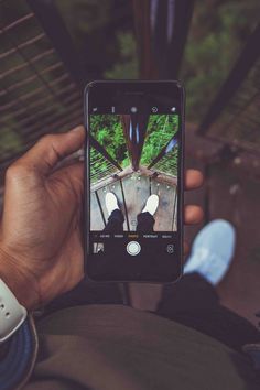 someone holding up their cell phone to take a selfie with the camera in front of them