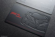 two black business cards with red accents on them