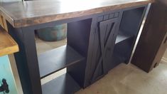 a kitchen island made out of wood and metal with an open door on the side