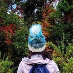 a woman wearing a blue backpack and a white hat