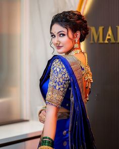 a woman in a blue sari and gold jewelry