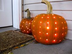 two lighted pumpkins sitting on the front porch