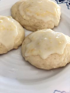 three biscuits with icing on a white plate