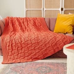 an orange blanket is draped over a couch