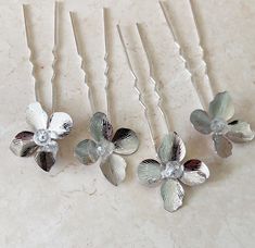 Enhance your special occasion hairstyle with these exquisite flower hair pins. Each pin features a stunning silver flower with a delicate crystal centre, meticulously hand-wired onto a silver hairpin. This set includes four beautiful hair pins, perfect for brides, bridesmaids, flower girls, or any special event. These flowers can be made with a pearl centre instead, please message to enquire. Also available in gold. Silver Hairpin, Occasion Hair, Flower Hair Pins, Silver Hair Pin, Special Occasion Hairstyles, Pearl Accessories, Messy Buns, Wedding Hair Pins, Sleek Ponytail