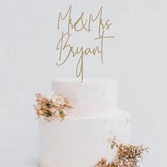 there is a wedding cake with flowers on the top and gold lettering that says be my bridal