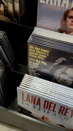 various cd's are stacked on top of each other in a store display case