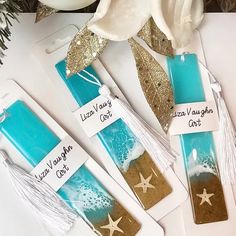 three blue and white candles with starfish designs on them are sitting next to each other