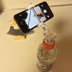 a cell phone sitting on top of a bottle with a camera attached to the back