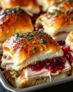 ham and cheese sliders with cranberry sauce in a baking pan ready to be eaten