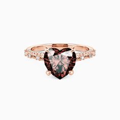 a heart shaped pink diamond ring with diamonds on the band and side stones in rose gold