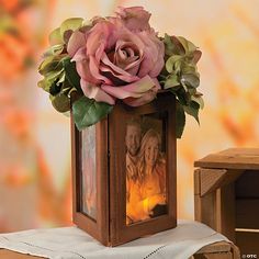 a candle is lit in front of a small wooden box with a photo on it