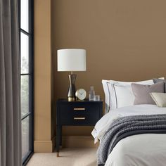 a bedroom with brown walls and white bedding