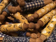 a pile of wooden sticks with yellow and black designs on them sitting next to each other