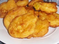 some fried food on a white plate with a blue checkered table cloth in the background