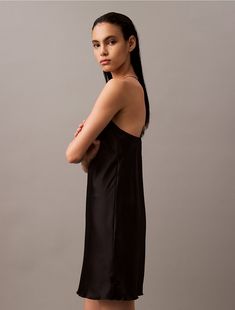 Elevated and sensual, this crossback slip dress is crafted from silky satin with a luxurious feel. Designed with a high neckline, spaghetti straps at the back and an elegant drape. Detailed with clean finish hems for a simple, timeless look.  Material: 100% Polyester. Chic Sleeveless Slip Dress With Built-in Bra, Chic Luxury Slip Dress With Built-in Bra, Black Sleeveless Modal Satin Slip Dress, Sleeveless Black Slip Dress With Built-in Bra, Black Straight-neck Sleek Slip Dress, Elegant Drapes, High Neckline, Spaghetti Strap, Calvin Klein