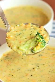 a spoon full of broccoli and cheese soup