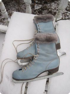 a pair of ice skates sitting on top of snow covered ground