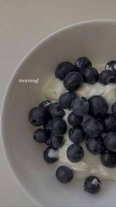 blueberries and yogurt in a white bowl on a table top with the words morning written above it