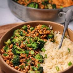 a bowl filled with rice and broccoli on top of a wooden cutting board