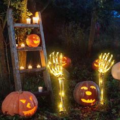 lighted pumpkins in the grass with candles on them and an old ladder next to them