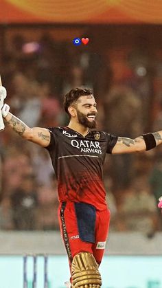 a man in black and red uniform holding his arms out to the side with one hand up