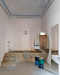 a bathroom with two stools and a mirror on the wall next to each other